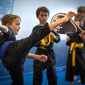 children kicking targets in martial arts class